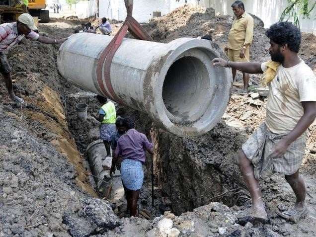 Lowering a large-diameter sewer pipe into the trench